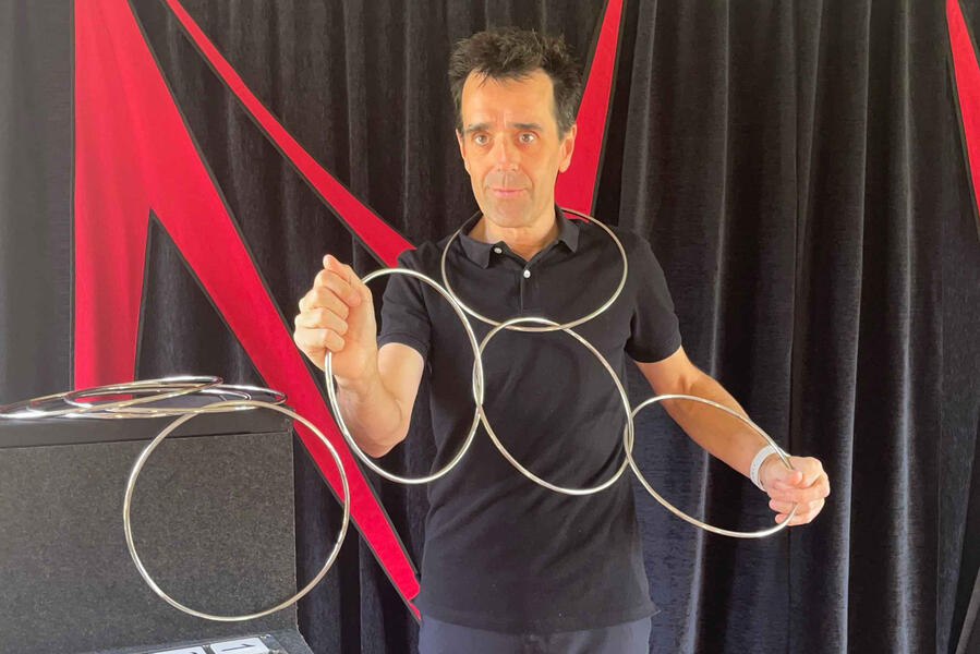 Monsieur Fred présente un livre magique et utilise une boîte pour faire apparaître des doudous sur scène, émerveillant le jeune public lors du spectacle