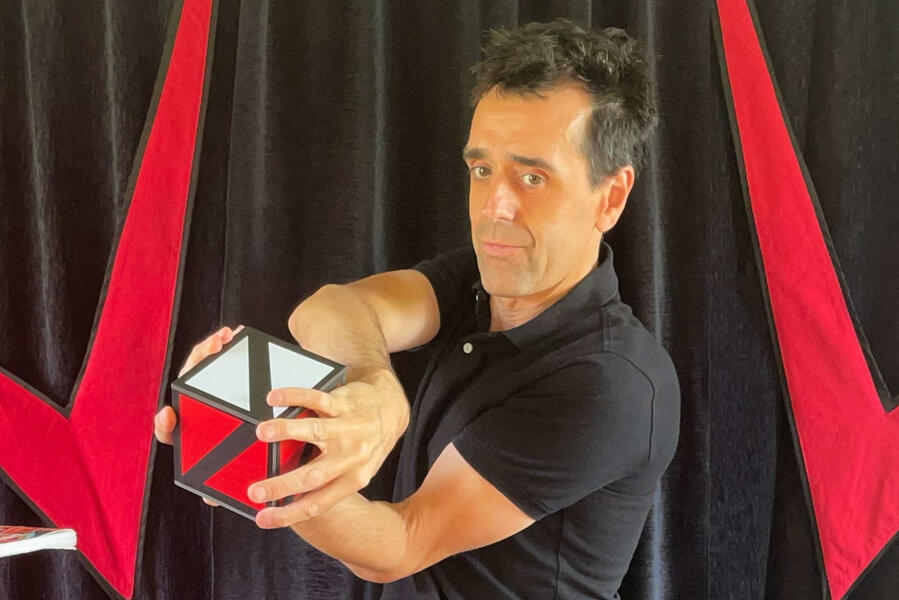Monsieur Fred réalise une apparition et transformation de foulards de couleurs vives lors d’un spectacle interactif, captivant enfants et familles avec ses effets visuels.