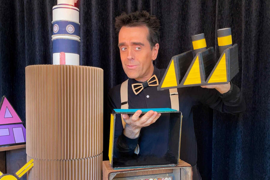 Monsieur Fred présente les accessoires du décor aux enfants pendant un spectacle dans une école privée en Normandie