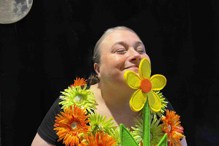 Aurore est comédien est en train de se cacher est en train de sentir une fleur avec son beau costume lors d'un spectacle à Abbeville